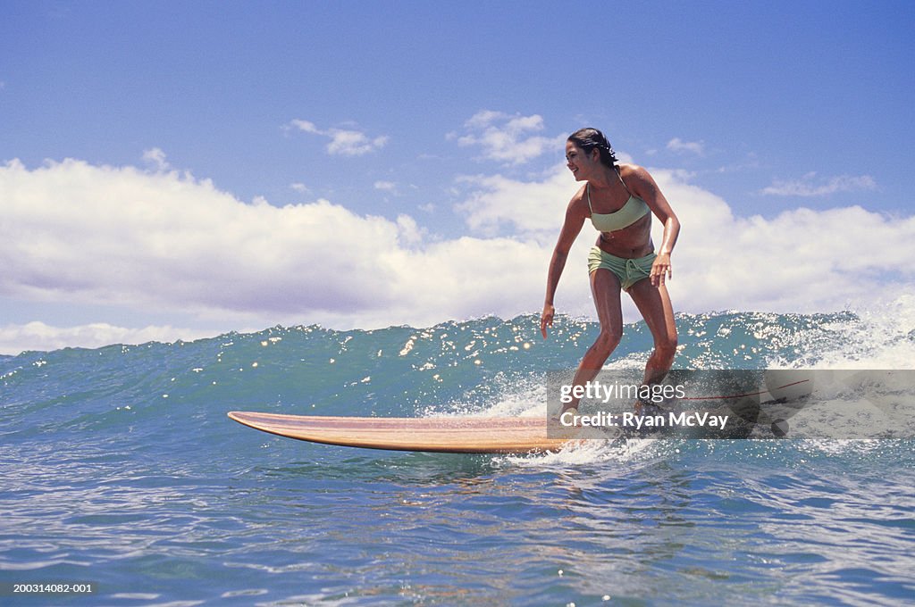 Woman surfing on ocean wave