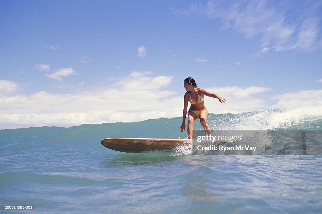 Woman surfing on ocean wave