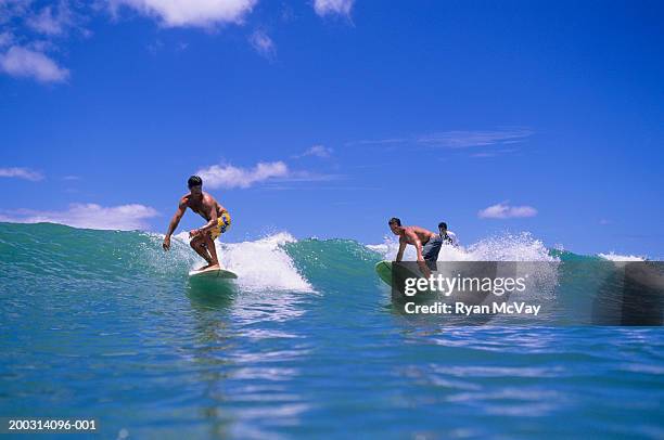 three men surfing on ocean wave - side by side stock pictures, royalty-free photos & images
