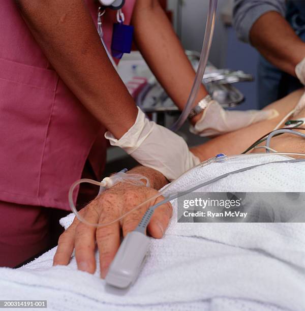 medical staff taking care of patient, close-up, mid section - iv drip womans hand fotografías e imágenes de stock