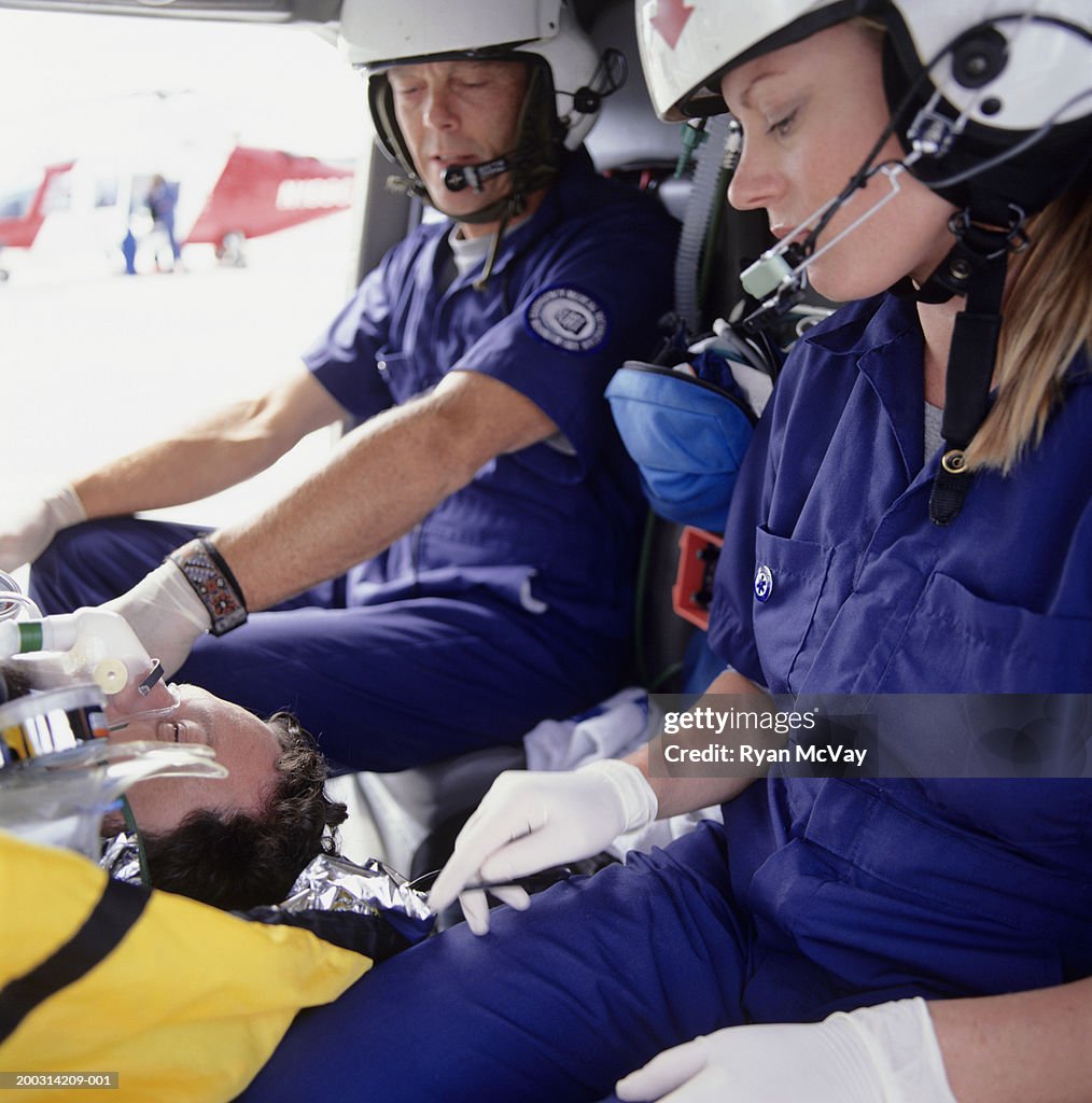 Emergency rescue workers with patient in helicopter