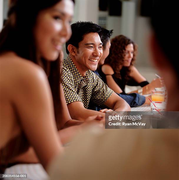 medium group of young people sitting at bar in club - medium group of people imagens e fotografias de stock
