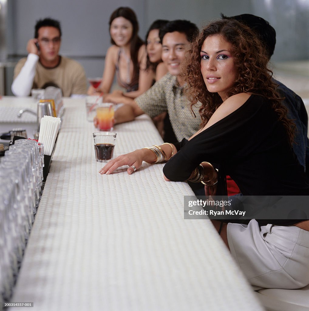 Medium group of young people sitting at bar in club
