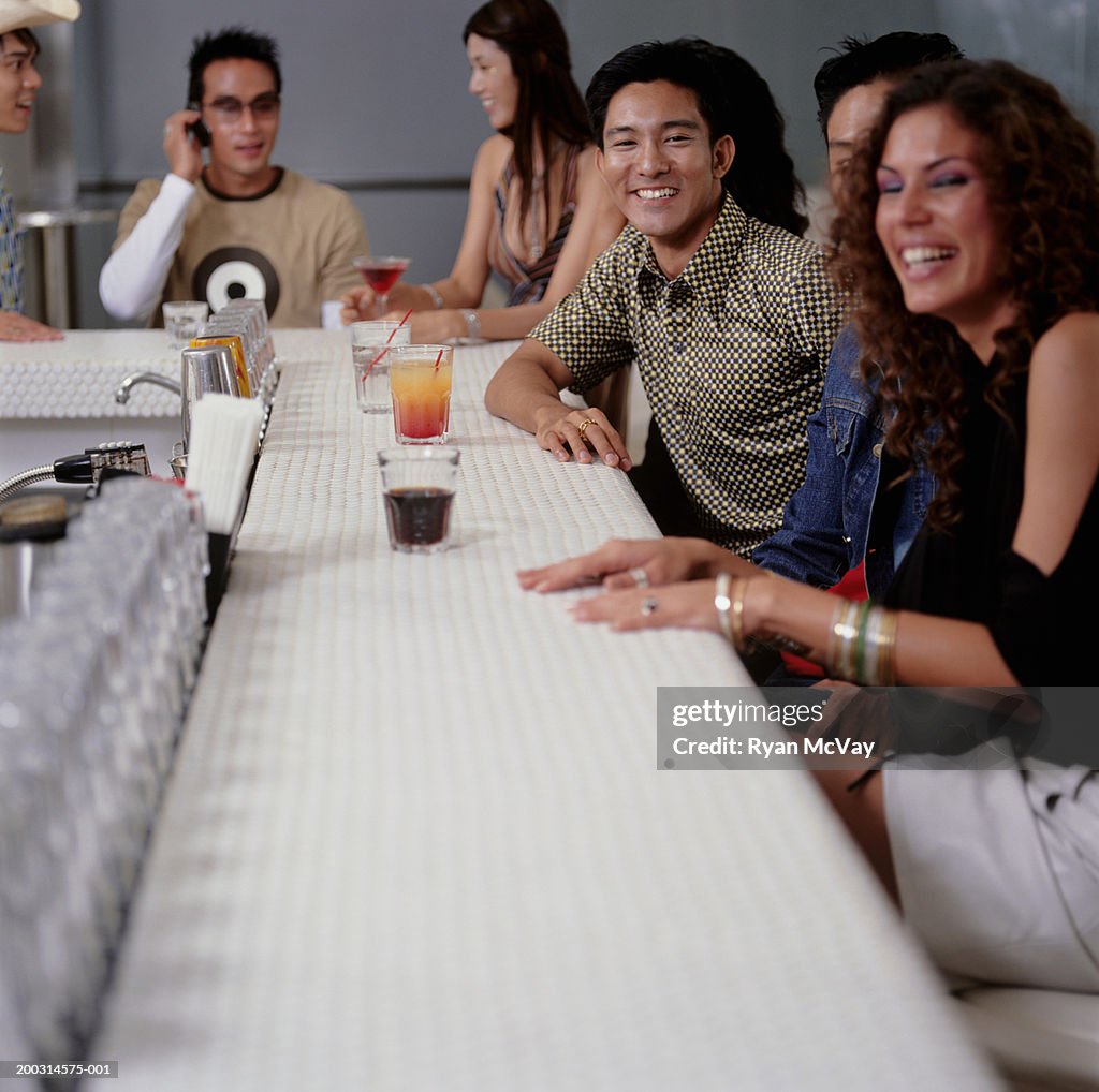 Medium group of young people sitting at bar in club