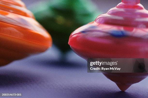 three spinning tops in motion, close-up - spinning top stock pictures, royalty-free photos & images