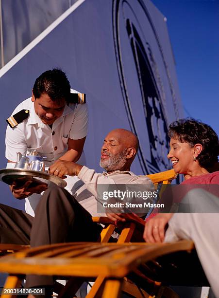 serving drinks to mature couple, on deck of cruise ship - cruise crew stock pictures, royalty-free photos & images