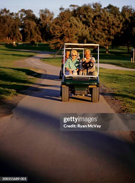 four people in carts on golf course - old man golf cart stock pictures, royalty-free photos & images