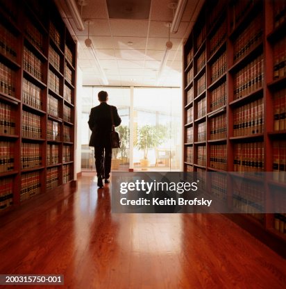 Woman Walking Between Book Shelves In Library Stock-Foto - Getty Images