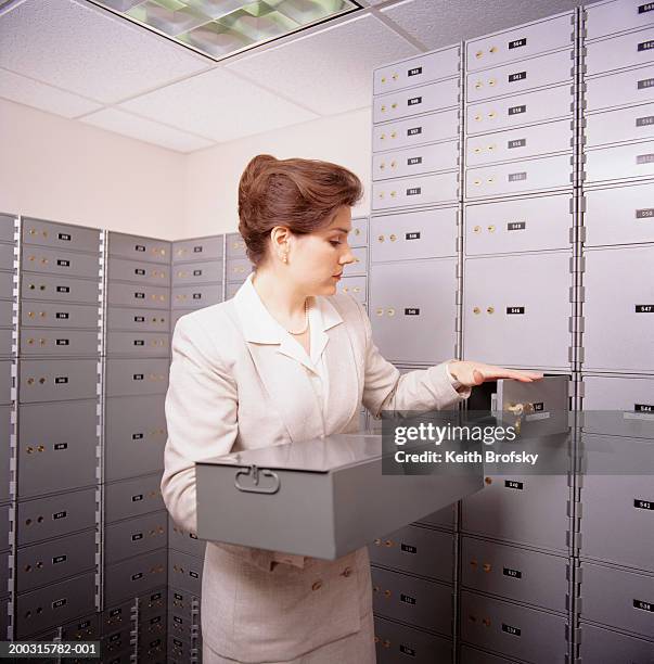 woman opening safe box in bank - safety deposit box stock pictures, royalty-free photos & images