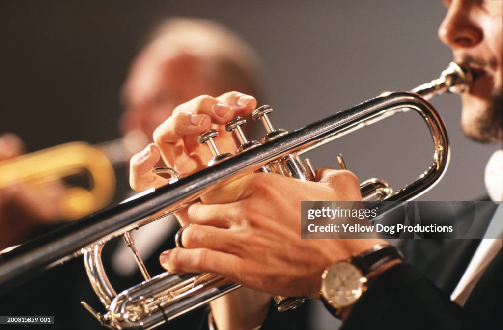 Man playing trumpet, side view, close-up