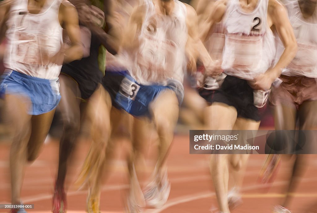 Track athletes running on track (blurred motion), low section