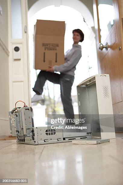 opened hard drive of computer with woman carrying box in background - careless stock pictures, royalty-free photos & images