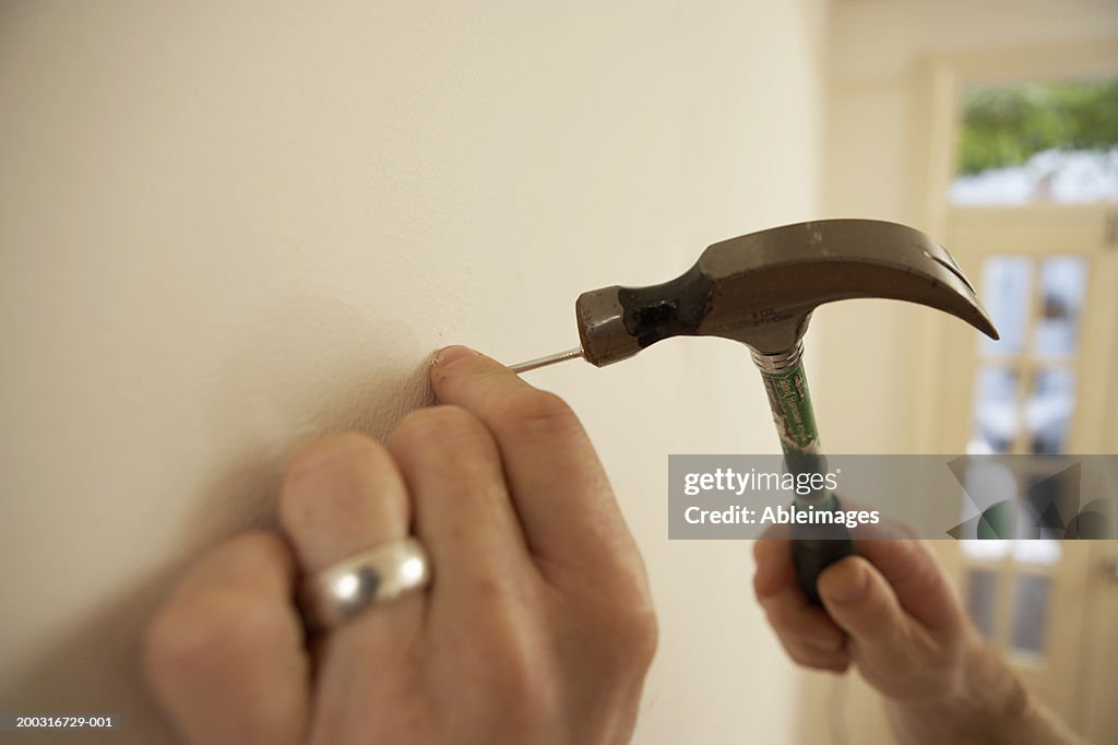 Man Hammering Nail Into Wall Closeup High-Res Stock Photo - Getty Images