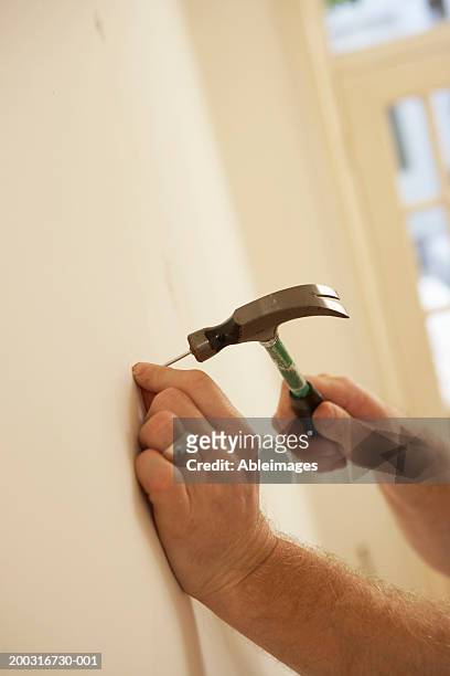 Man Hammering Nail Into Wall Closeup High-Res Stock Photo - Getty Images