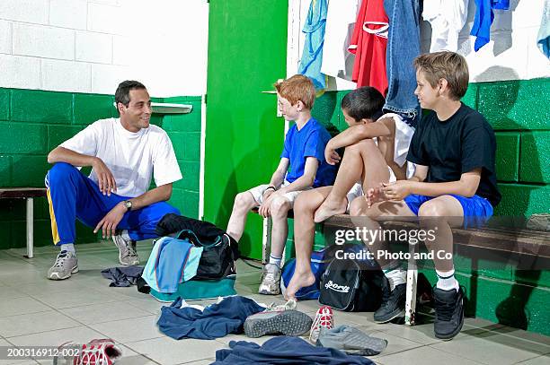 coach in changing room talking to boys (9-12) sitting on bench - young boys changing in locker room 個照片及圖片檔