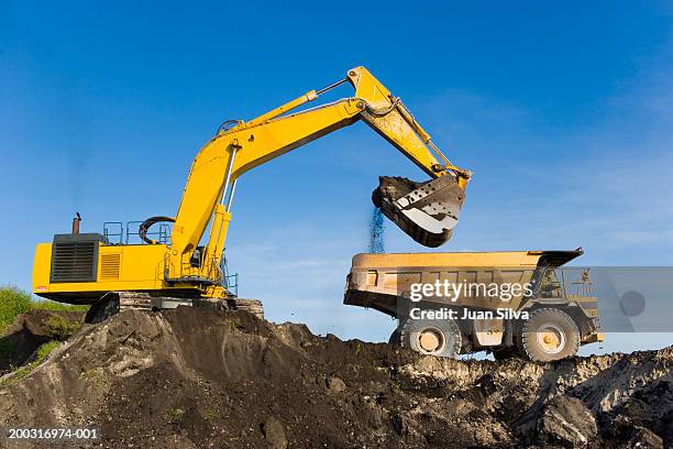 evcavator and dump truck - maquinaria de construcción fotografías e imágenes de stock