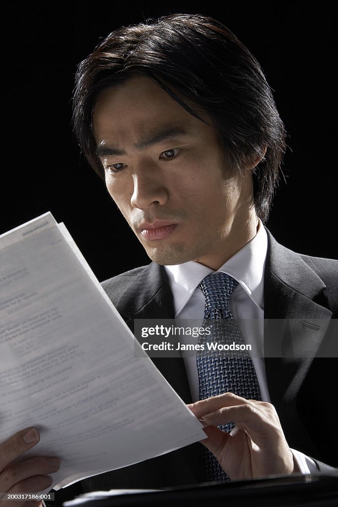 Businessman reading document, close-up