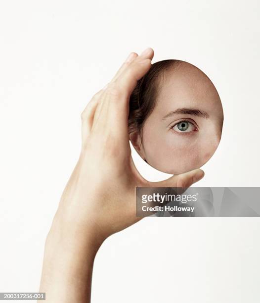 young woman holding oval mirror, face reflected in mirror, close-up - vanity stock pictures, royalty-free photos & images