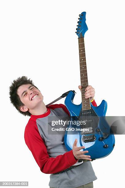 teenage boy (13-15) holding electric guitar, head back, eyes closed - エレキギター ストックフォトと画像