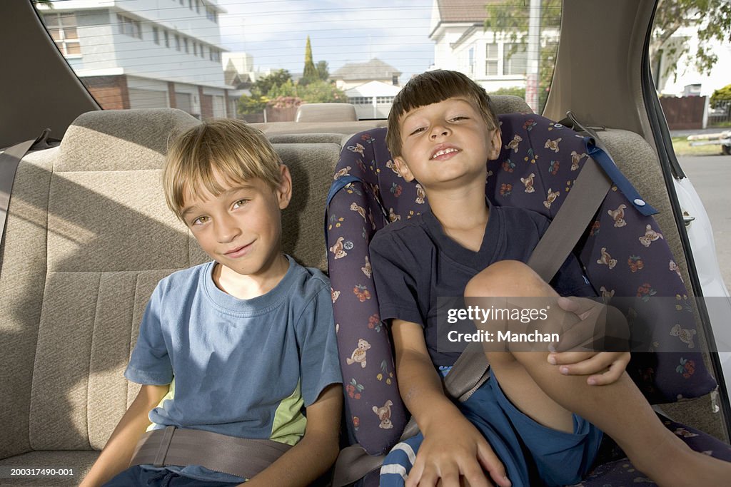 Brothers (4-7) in back seat of car, smiling, portrait