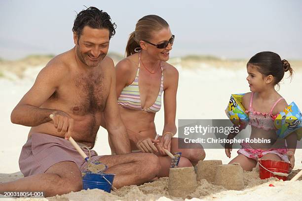 couple on beach building sandcastles with daughter (2-4) - female hairy chest photos et images de collection