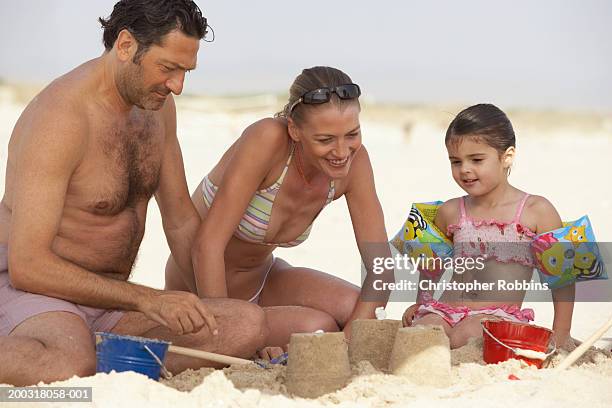 couple on beach building sandcastles with daughter (2-4) - female hairy chest photos et images de collection