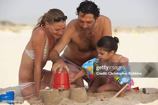 couple on beach building sandcastles with daughter (2-4) - female hairy chest stock-fotos und bilder