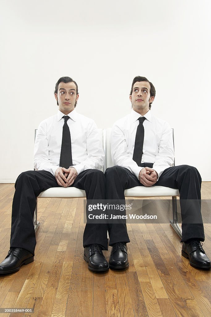 Young male twins wearing shirts and ties, looking in opposite directions