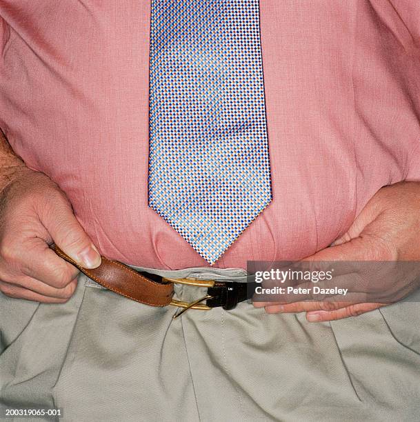 mature man tightening belt, mid section, close up - tighten stock pictures, royalty-free photos & images