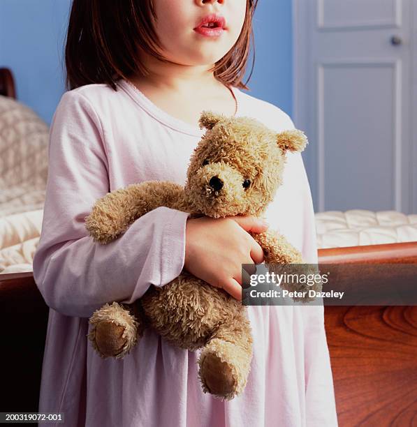 girl (4-6) holding teddy bear in bedroom, close up - nightdress stock pictures, royalty-free photos & images