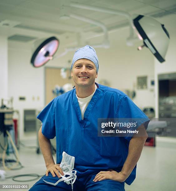 male surgeon wearing surgical scrubs in operating room, portrait - male doctor portrait stock-fotos und bilder