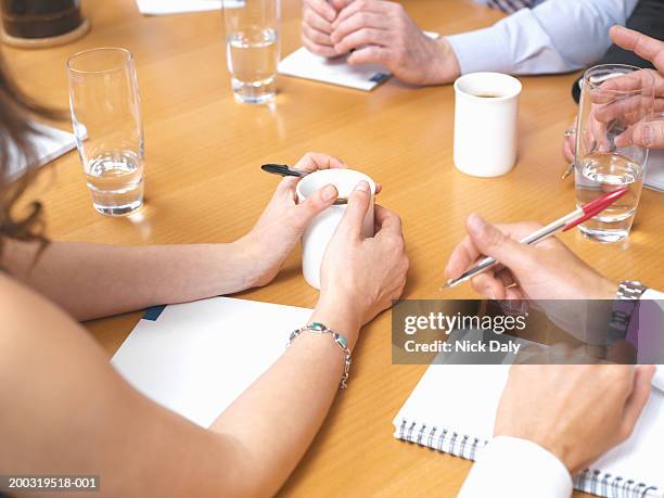 business colleagues with drinks and notepads on table in meeting - mesa de reunião - fotografias e filmes do acervo