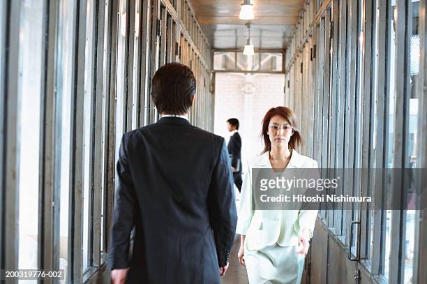 business colleagues walking in corridor - moving past fotografías e imágenes de stock