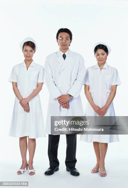 male doctor standing with two nurses, portrait - nurse hat stock pictures, royalty-free photos & images