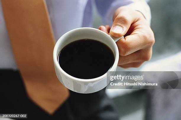 businessman holding cup of black coffee, mid section, elevated view - black coffee stock pictures, royalty-free photos & images
