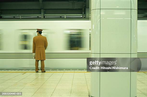 police officer standing on railway platform, rear view - moving past ストックフォトと画像