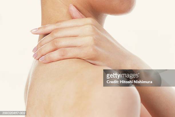 woman with hand on neck, mid section, close-up - shoulder ストックフォトと画像
