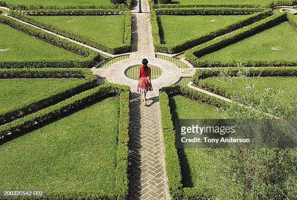 young woman walking in formal garden, elevated view - choices stockfoto's en -beelden