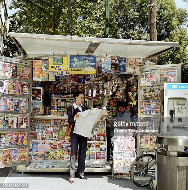 businesswoman reading newspaper at kiosk - banca de jornais imagens e fotografias de stock