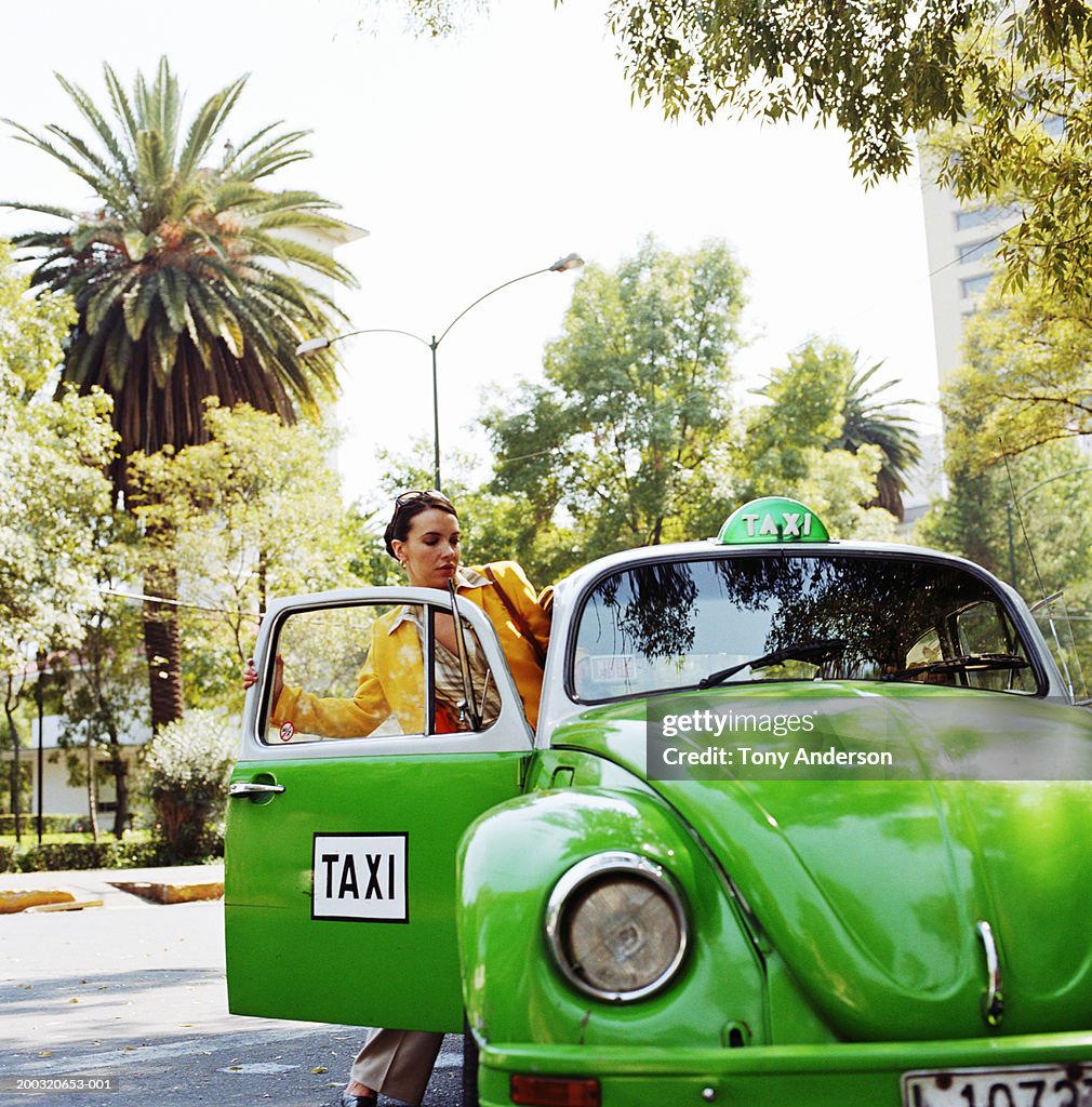 Businesswoman getting into taxi