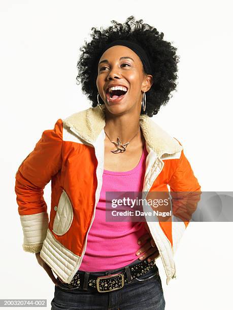 young woman with hands on hip laughing - portrait white background looking away stockfoto's en -beelden