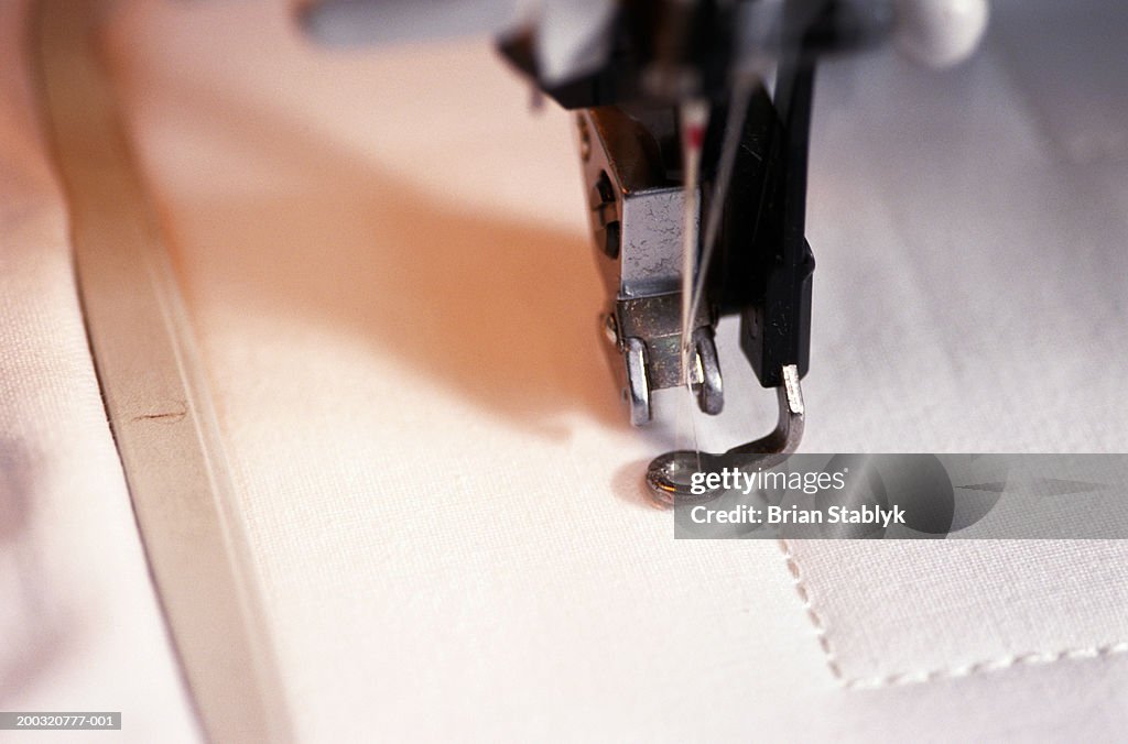 Close-up of sewing machine needle stitching cloth