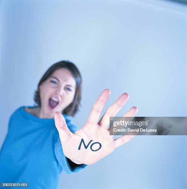 young woman showing 'no' written on hand, focus on hand - women's self defense stock pictures, royalty-free photos & images