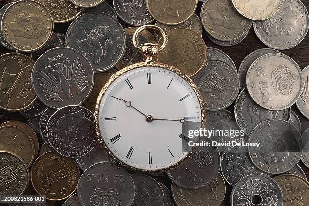 pocket watch and collection of coins - römische zahl stock-fotos und bilder