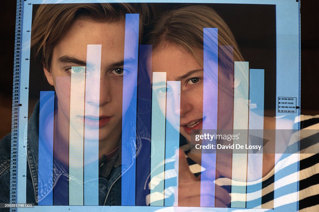 Teenage girl and boy (16-17) looking at bar graph in computer screen