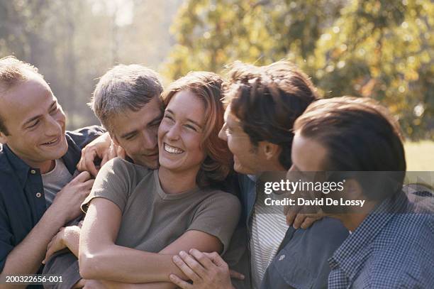 woman with group of males, smiling - female with group of males stock-fotos und bilder