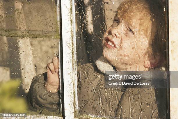 boy (3-5) looking out window with rain running down - kid looking down stock pictures, royalty-free photos & images