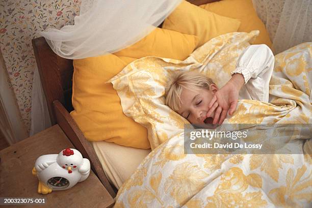 girl (6-7) yawning in bed, eyes closed, elevated view - david de lossy sleep stock pictures, royalty-free photos & images