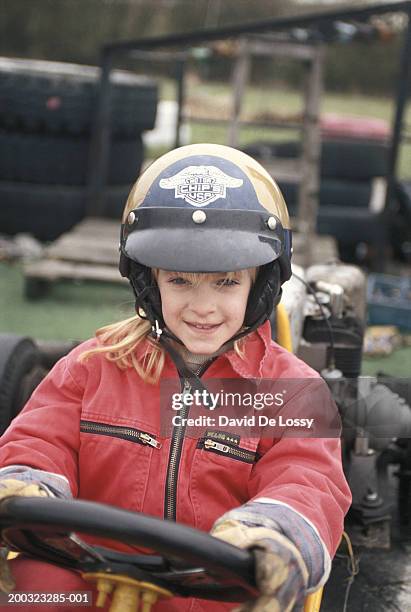 girl (6-7) sitting in race car, smiling - de lossy girl stock pictures, royalty-free photos & images