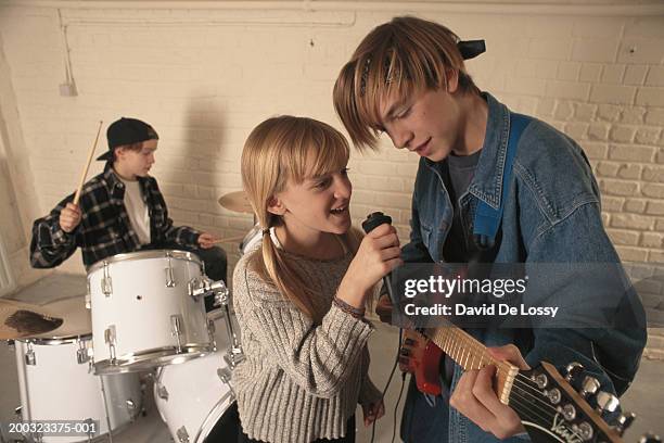 children (8-15) with musical band, girl singing into microphone - boy band stockfoto's en -beelden